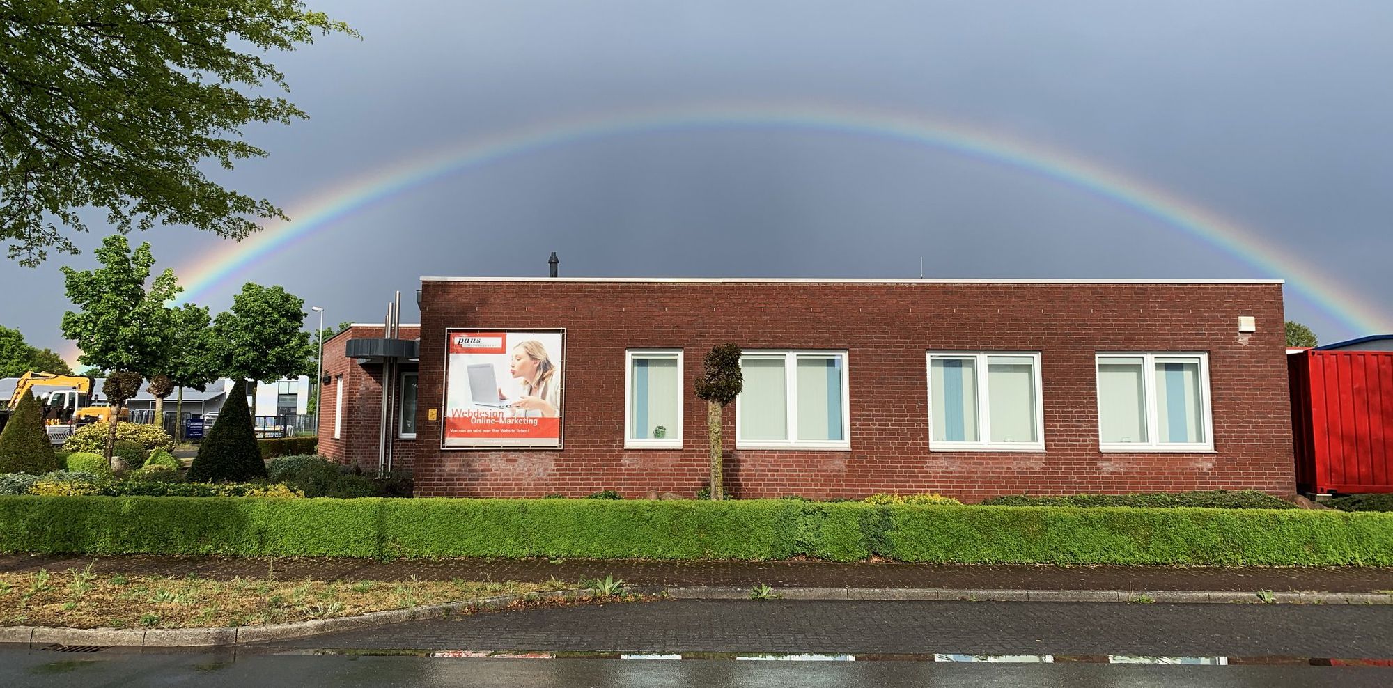 Agenturgebäude von Paus Design & Medien im Industriepark Bocholt-Mussum, darüber ein Regenbogen