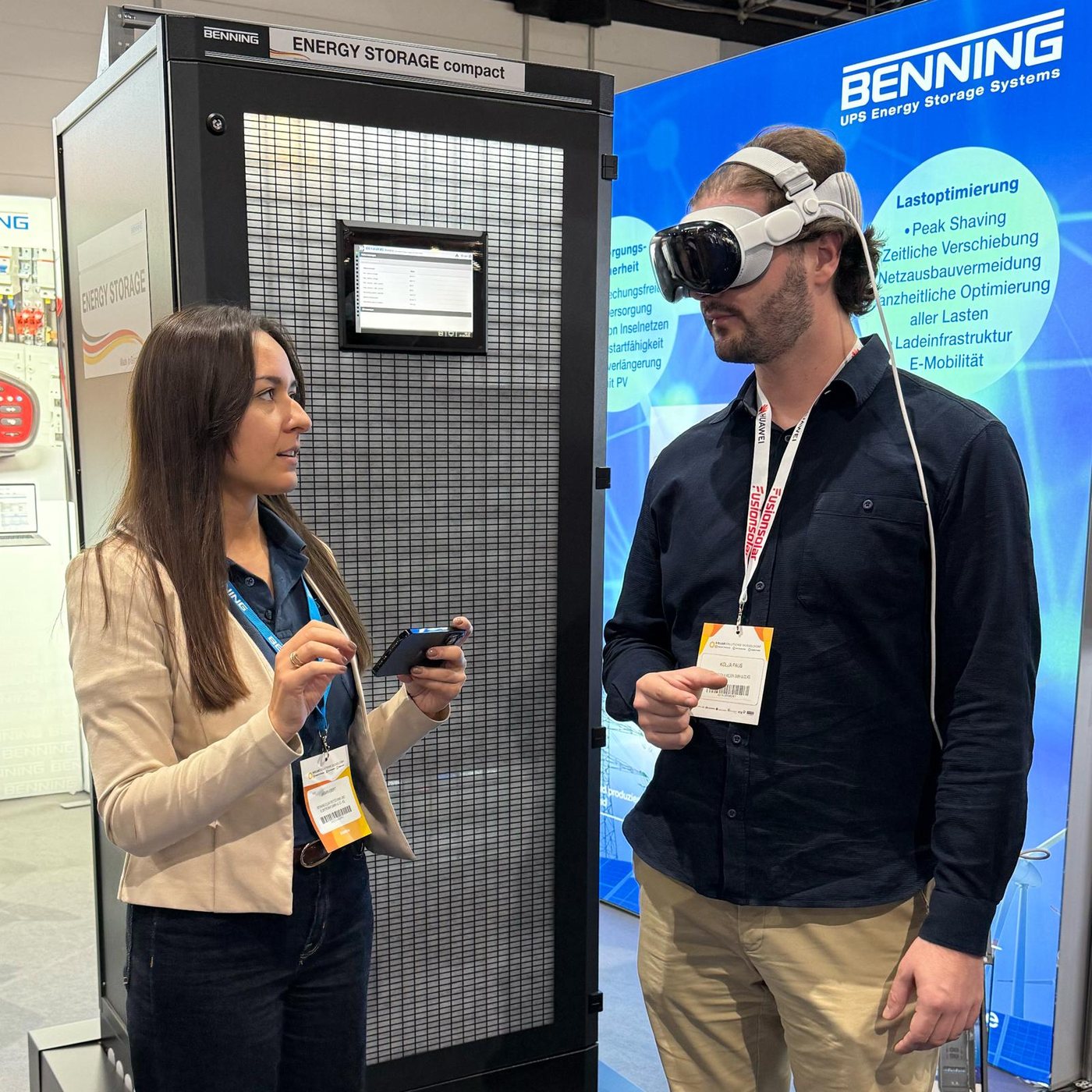 Kolja Paus betrachtet mit einer Apple Vision Pro ein Produkt am Messestand von BENNING, daneben steht ein Energiespeicher-Schrank