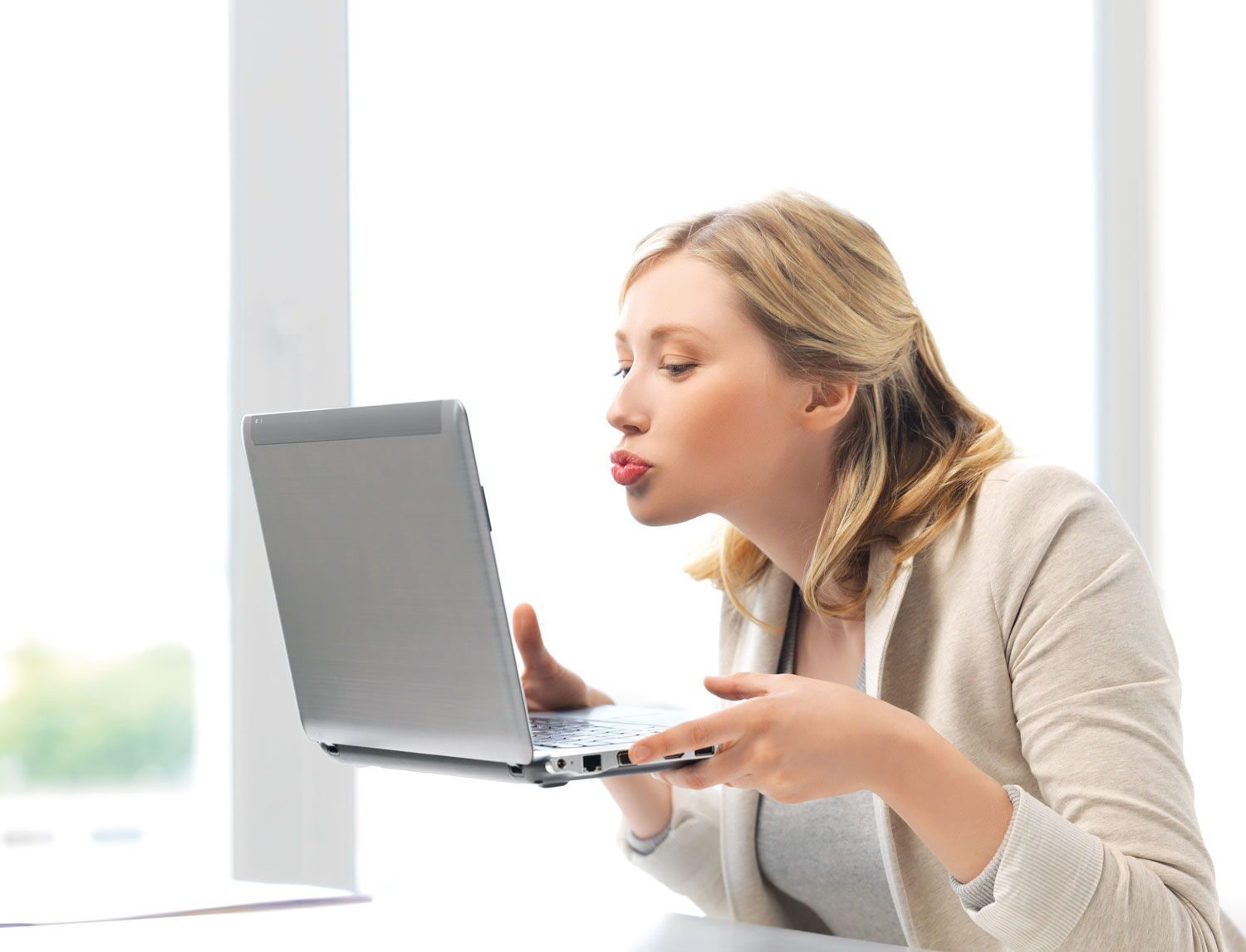 Frau küsst ihren Laptop, weil sie ihre neue Website liebt