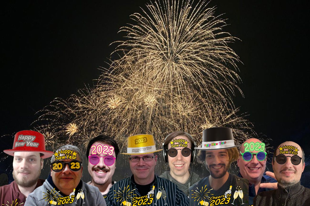Acht Personen mit virtuellen Silvesterhüten und Partybrillen mit „Happy New Year“ und „2023“ vor goldenem Feuerwerk